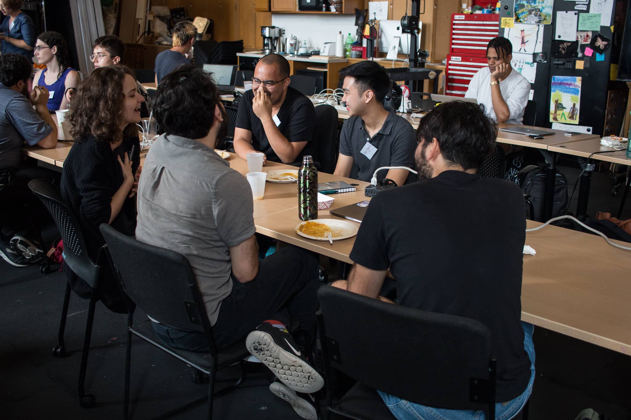 Participants sitting at a long table having lunch and a discussion