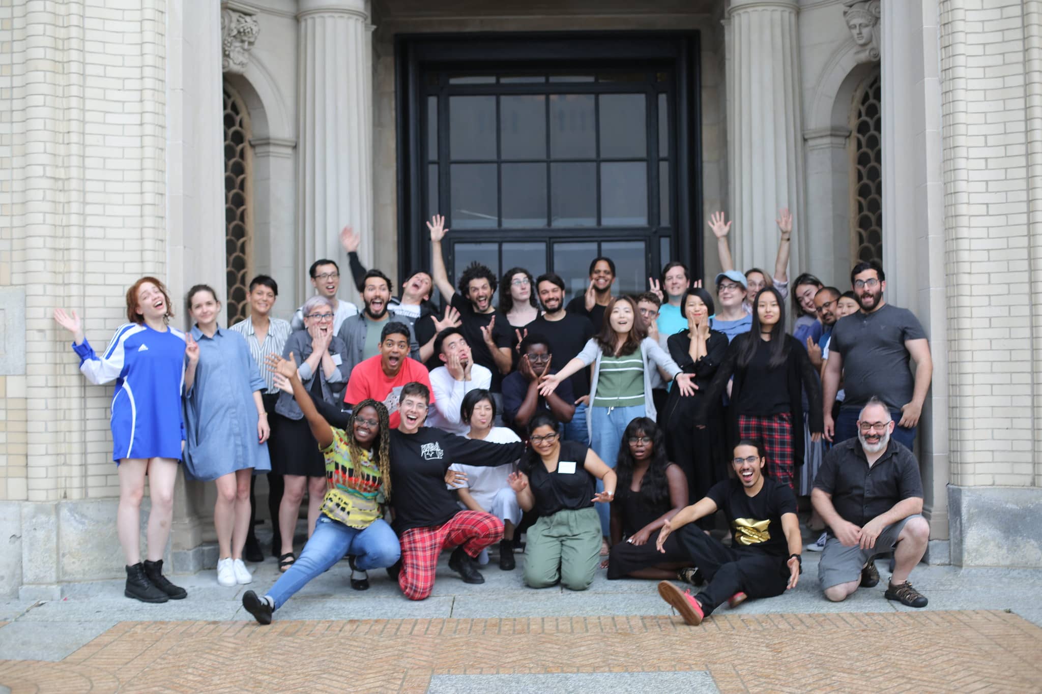 Group photo of participants smiling enthusiastically with their hands in the air