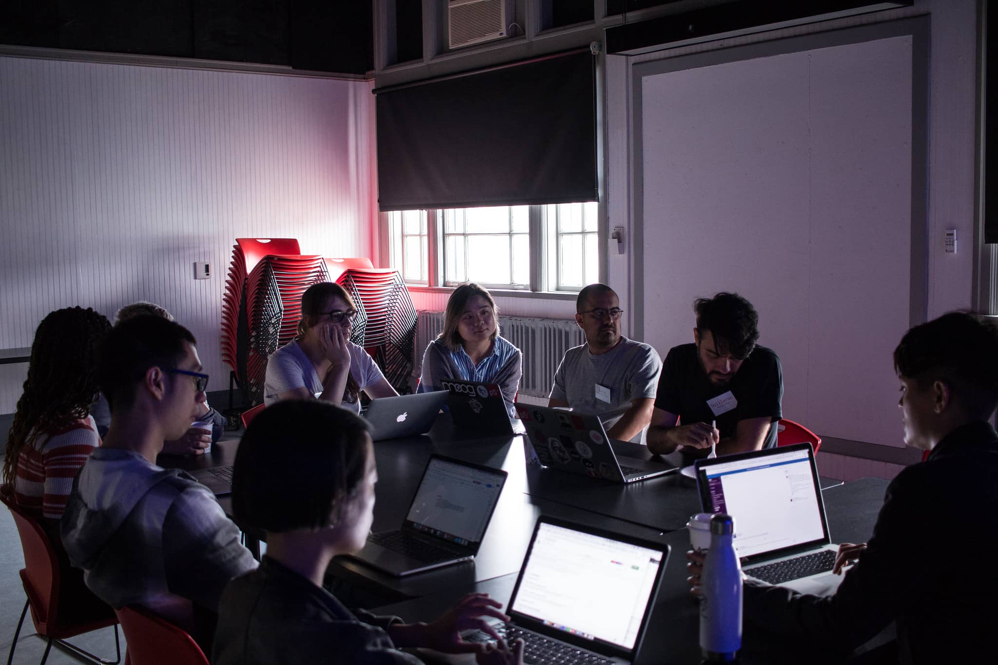 Participants in a meeting in a dark classroom