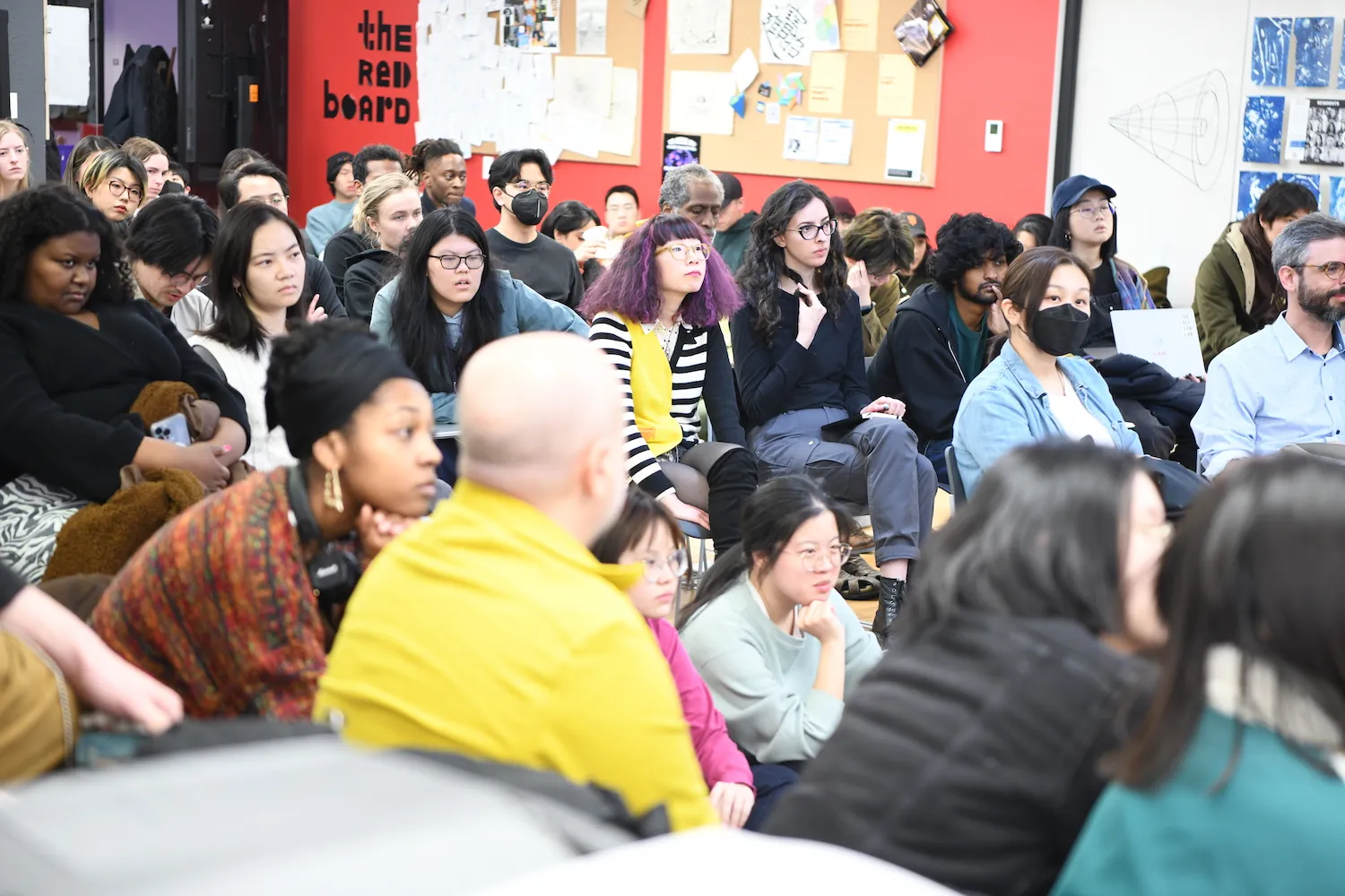 p5.js salon audience are sitting in a crowded room with curious and serious expression.