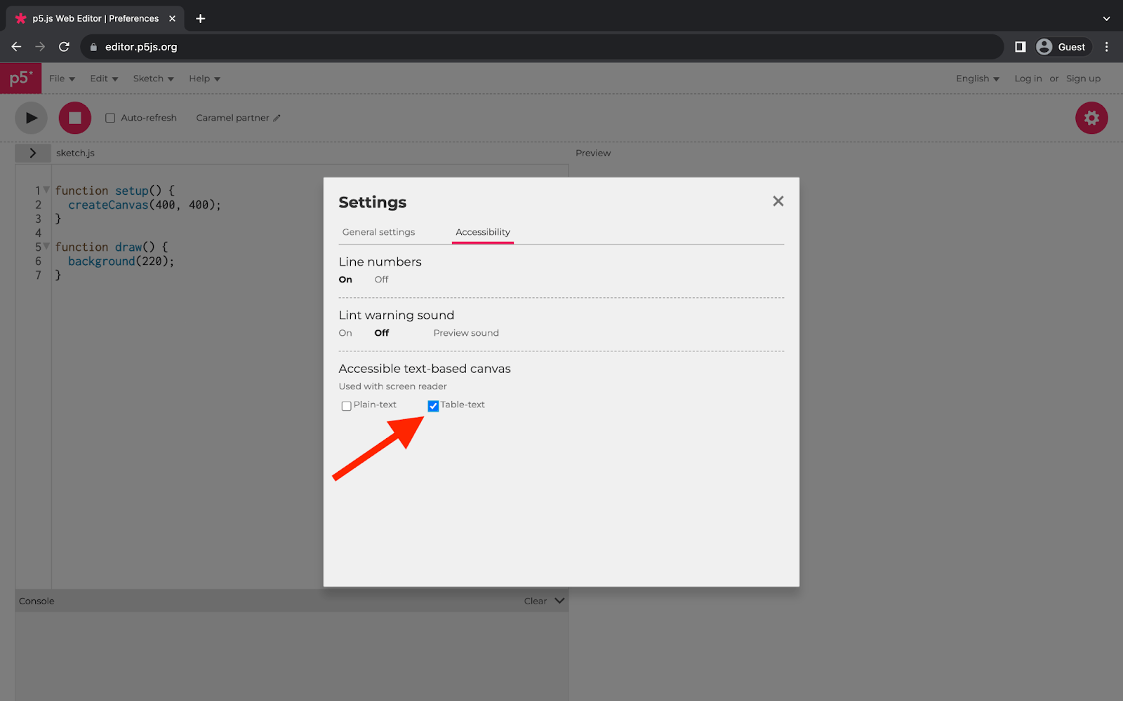 p5.js Webエディタを表示しているウェブブラウザ。ページ中央の四角いメニューにアクセシビリティ設定が表示されています。メニューの「Accessible text-based canvas」セクションに赤い矢印が指しています。「Table-text」オプションがチェックされています。
